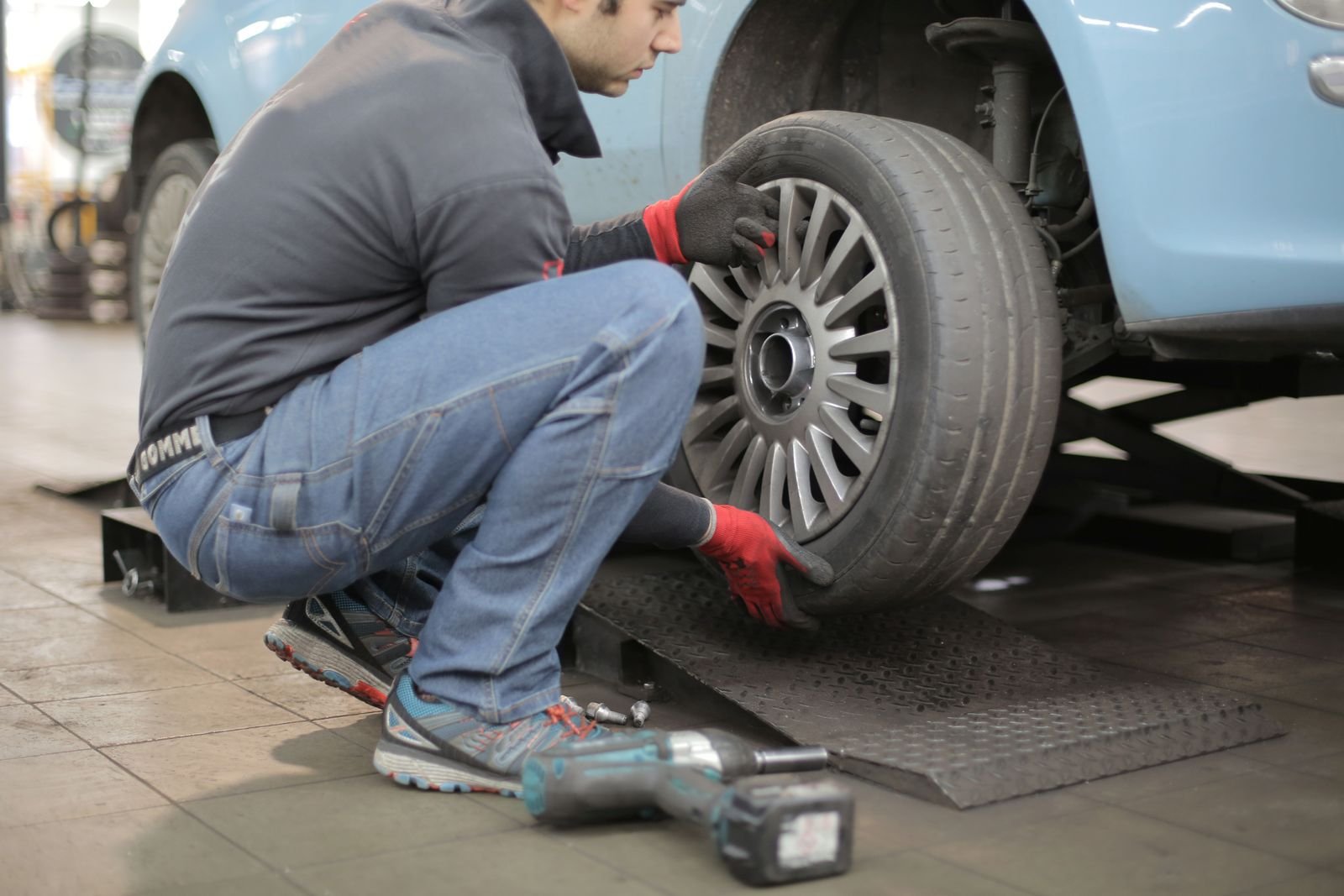 Professional mechanic fitting a car tyre